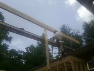 Carpenter setting a ridge beam over a new addition frame — Ice Dam Removal by Roofing Brothers in Lewisburg